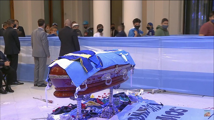 Torcedores jogam flores e camisas em direção ao caixão de Maradona durante velório na Casa Rosada