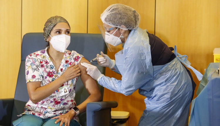 Chilena recebe uma das primeiras doses da vacina contra coronavírus. Chile é o único da América do Sul a começar o processo de imunização