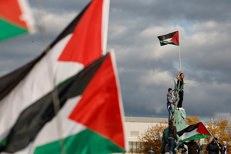 Manifestante empunha a bandeira palestina em fonte na cidade de Berlim (Alemanha) -