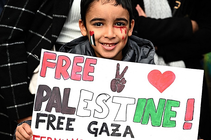 Menino segura cartaz com os dizeres 'Palestina Livre' durante protesto em Milão (Itália)