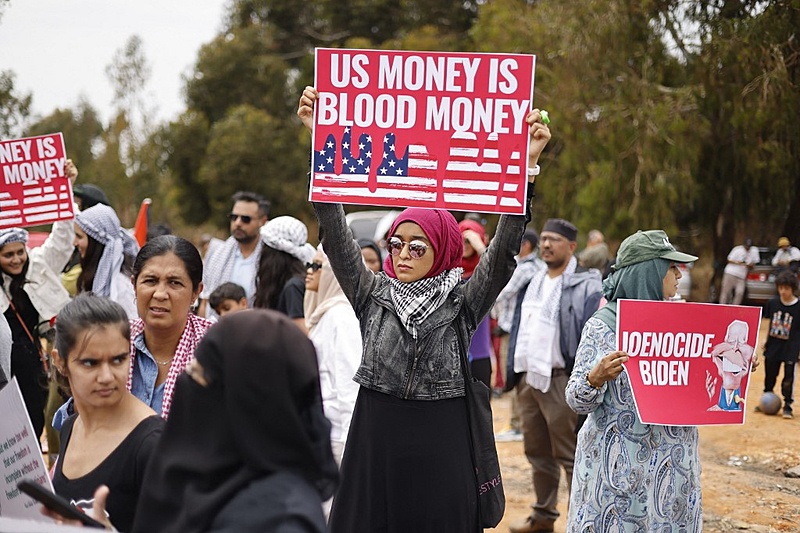 Participante de ato em Joanesburgo (África do Sul) segura cartaz com a frase 'Dinheiro dos EUA é dinheiro sujo de sangue'
