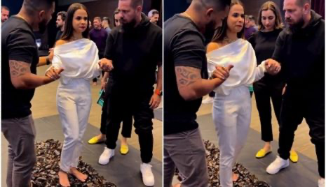 Durante sessão de coach motivacional em hotel de luxo com empresários, mulher anda sobre cacos