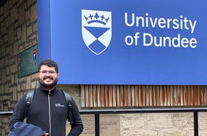 Dener Silva Miranda em frente ao logotipo da Universidade de Dundee, na Escócia, onde ele estudou pelo programa Ciência Sem Fronteiras(Reprodução)